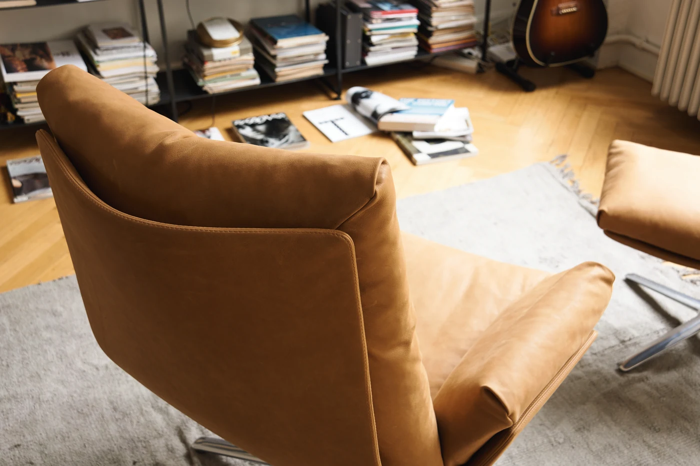 COR Cordia Lounge von hinten im Detail: cognacfarbener Lederbezug, geschwungene Schale und Naht