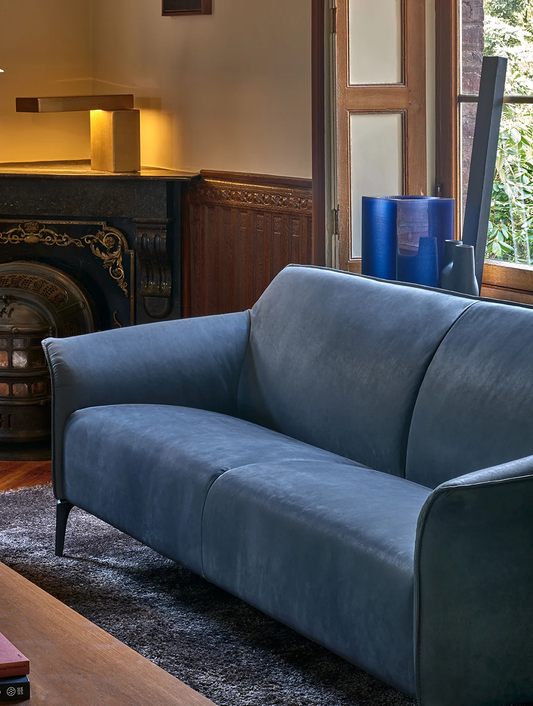 Blaues Leolux Mayon Sofa mit gepolsterten Armlehnen und schlanken Füßen