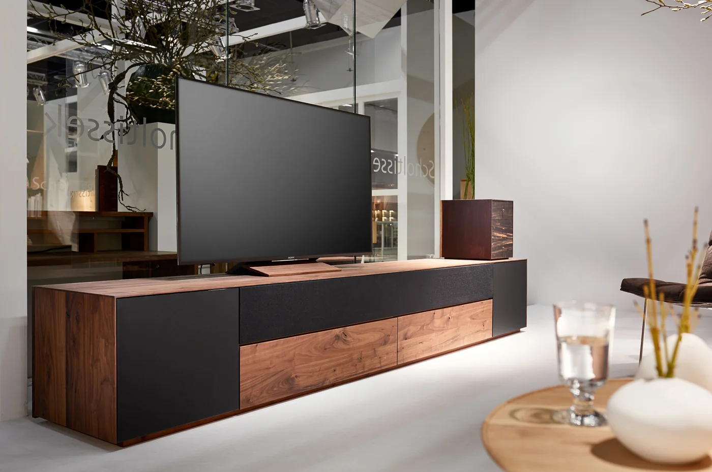 Wandhängende FARN-Medienanrichte mit Holz- und dunklen Glasflächen unter einem Fernseher