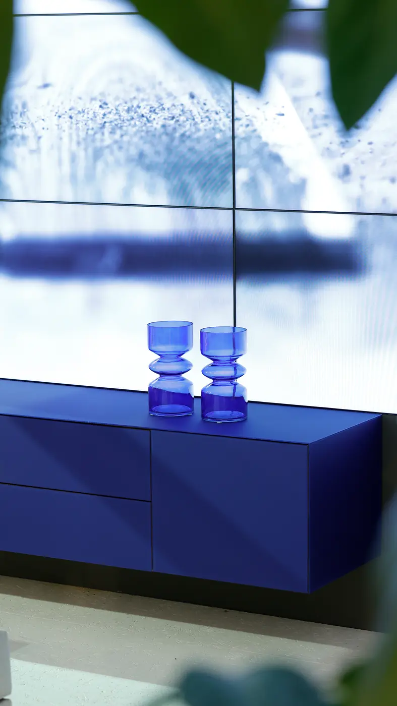 Blaue wandhängende NOVUS Medienanrichte vor einer Glasfassade
